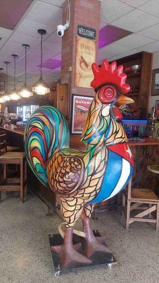 Hand-painted rooster statue on Calle Ocho — one of dozens of public sculptures that line Little Havana, painted with the Cuban flag colors.